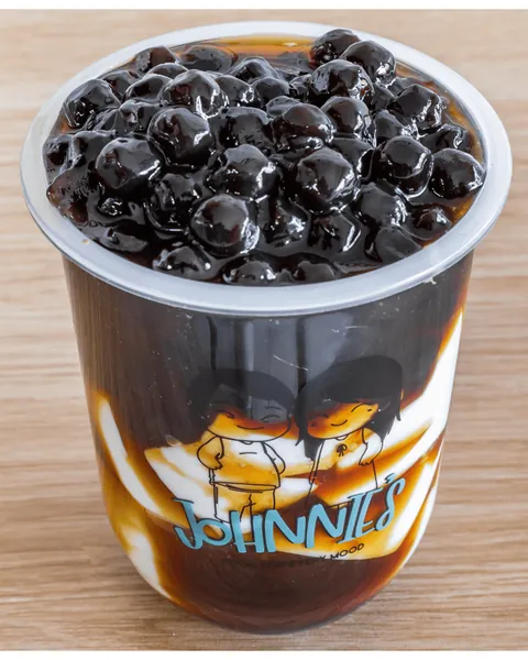 Brown sugar pearl milk tea loaded with tapioca pearls in a Johnnie's cup