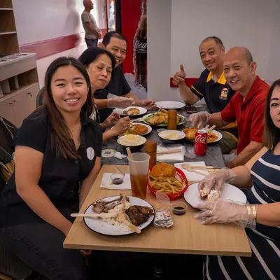 Family and friends sharing a table of Filipino food at Johnnie's Windsor