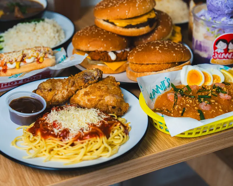 Filipino feast at Johnnie's: crispy fried chicken with sweet spaghetti, burgers, palabok and halo-halo on a wooden table