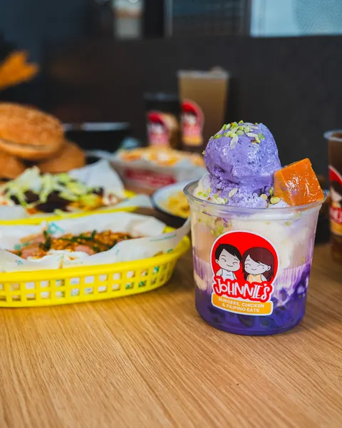 Halo-halo in a Johnnie's cup in front of a spread of burgers, palabok and loaded fries