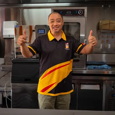 Johnnie's team member giving two thumbs up in the Windsor kitchen