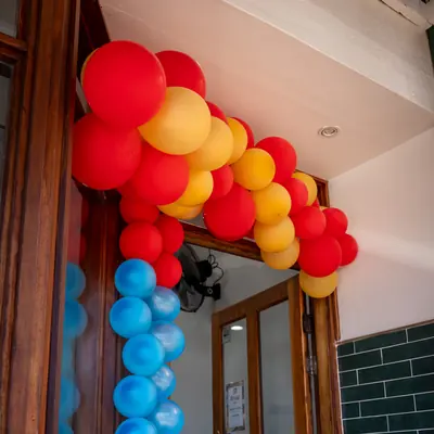Red, gold and blue balloon arch at the Johnnie's Windsor opening