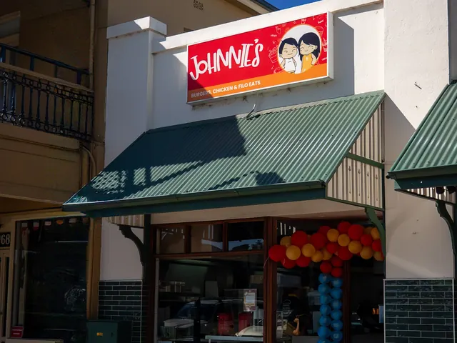Johnnie's storefront on George Street, Windsor NSW, with red sign, green awning and opening balloons