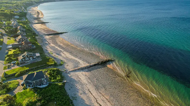 Aerial view of shingled homes along a sandy shoreline