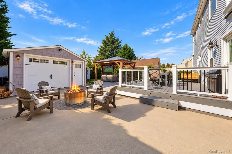 Paver patio with a fire pit and the detached garage