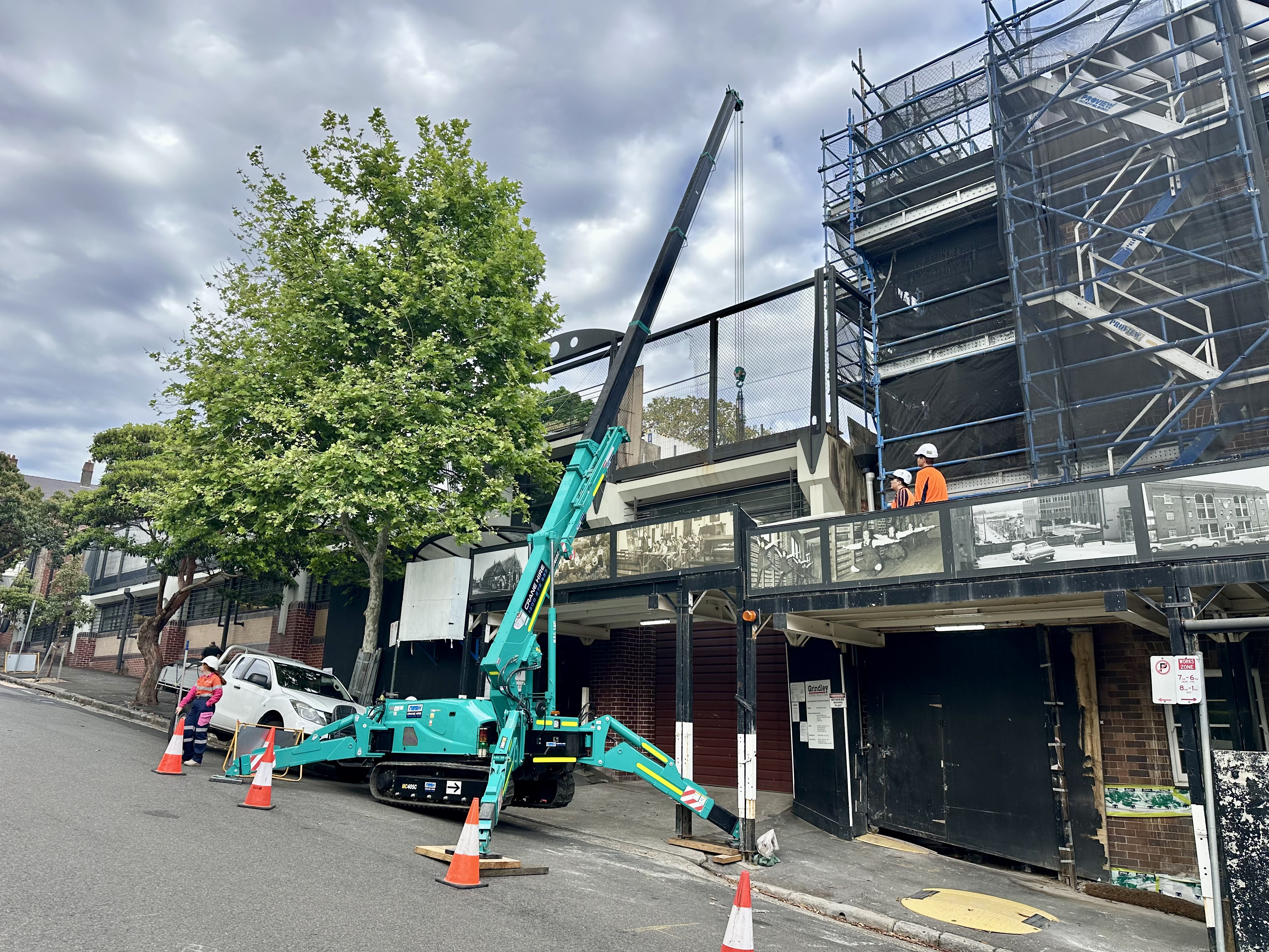 Nash crane lifting industrial steel structure at a warehouse construction site
