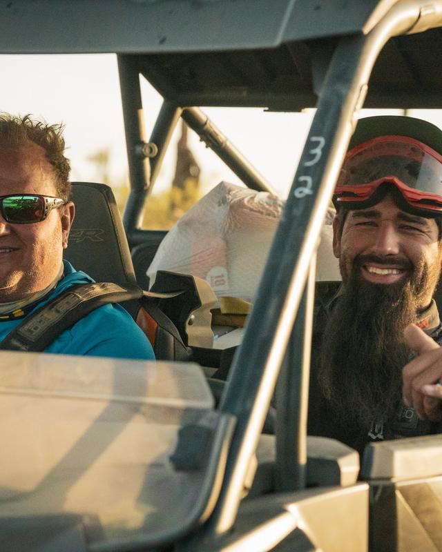 Two men riding in a side by side