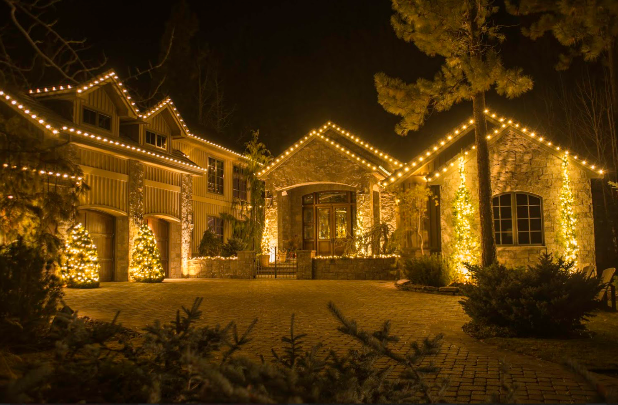 Large home and garage glowing with warm white roofline lights