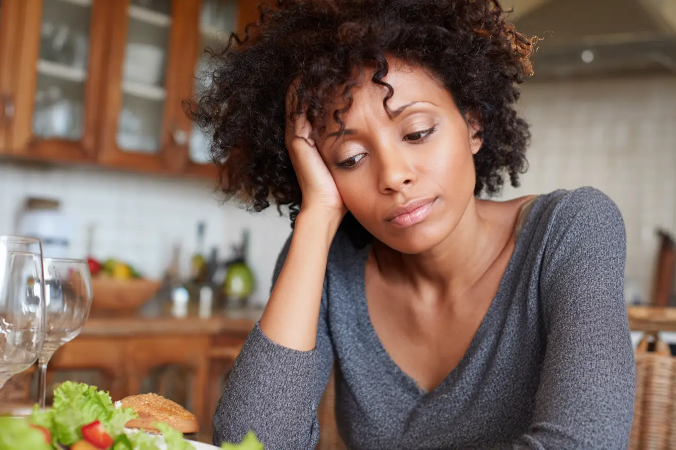 Black woman looking at dinner experiencing muted menopause hunger cues