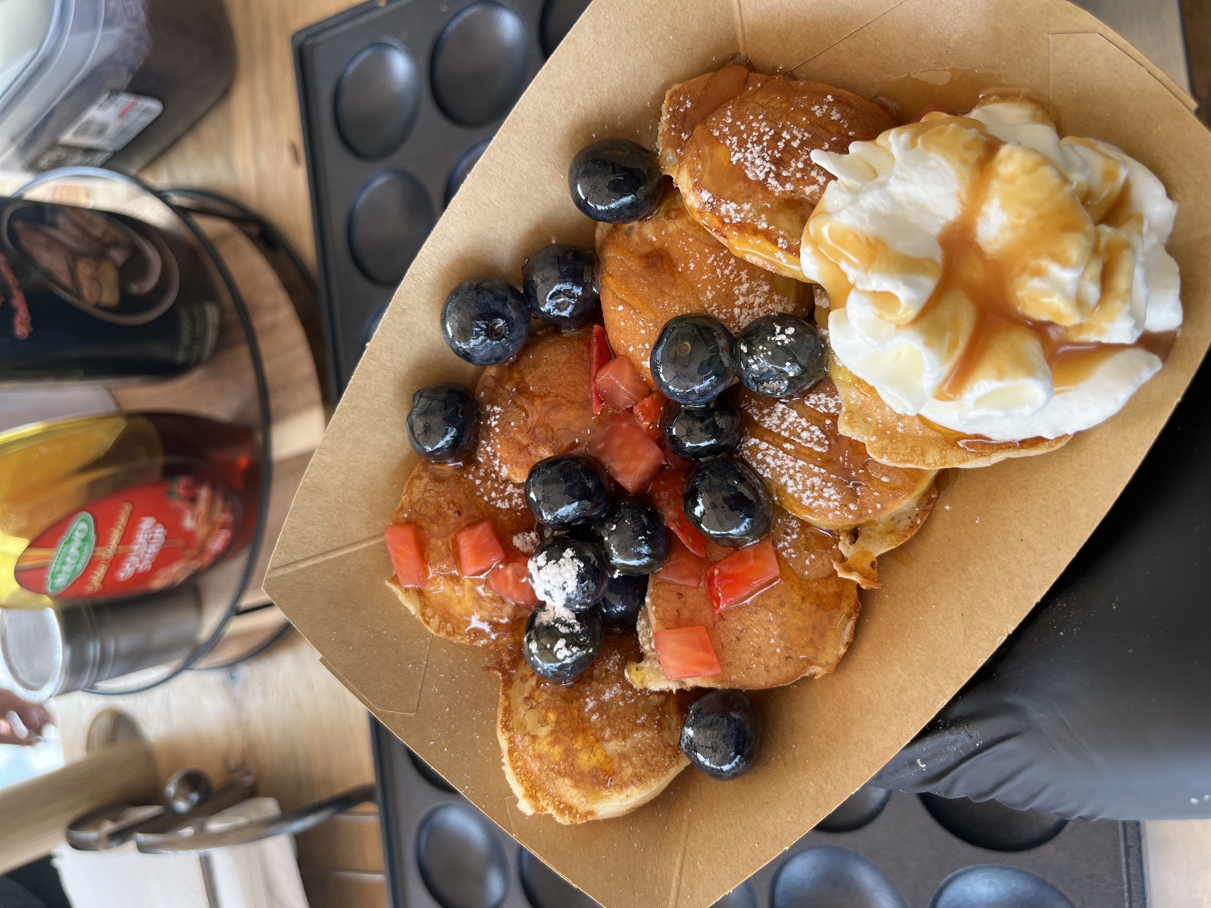 Fresh mini pancakes with whipped cream and generous toppings at Nibble & Nest event