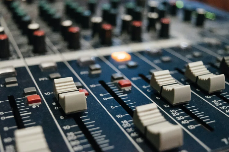 Close-up of a mixing console with sliders and knobs