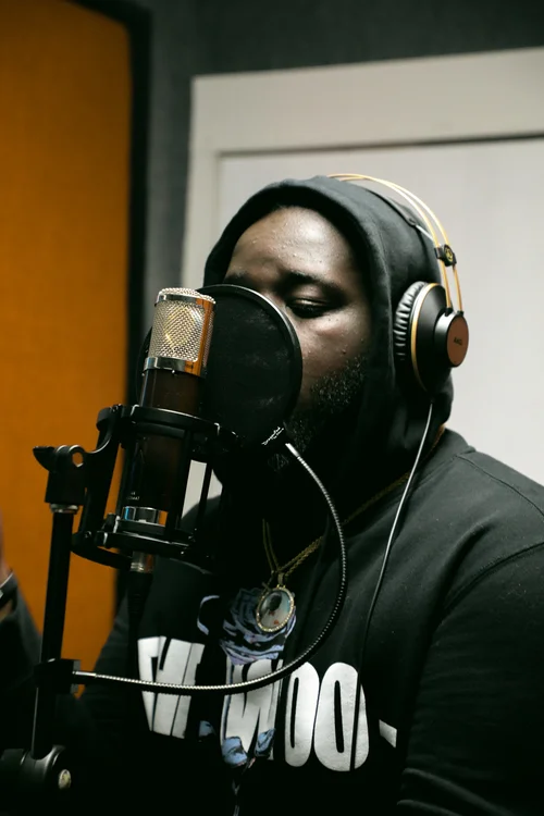 Two artists celebrating in the HighLife Studios recording booth