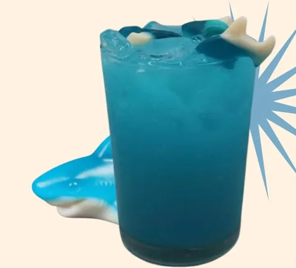 Gummy Shark Jazzed Energy drink at Sirincci Coffee, made with blue raspberry, passion fruit, cupcake, and cream, with a gummy shark on top