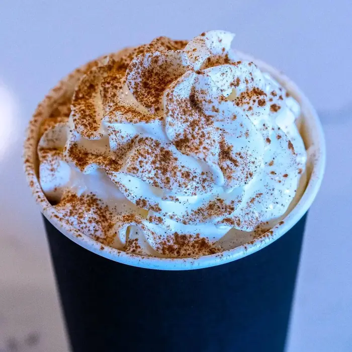 Hot specialty coffee topped with whipped cream and cinnamon at Sirincci Coffee Company