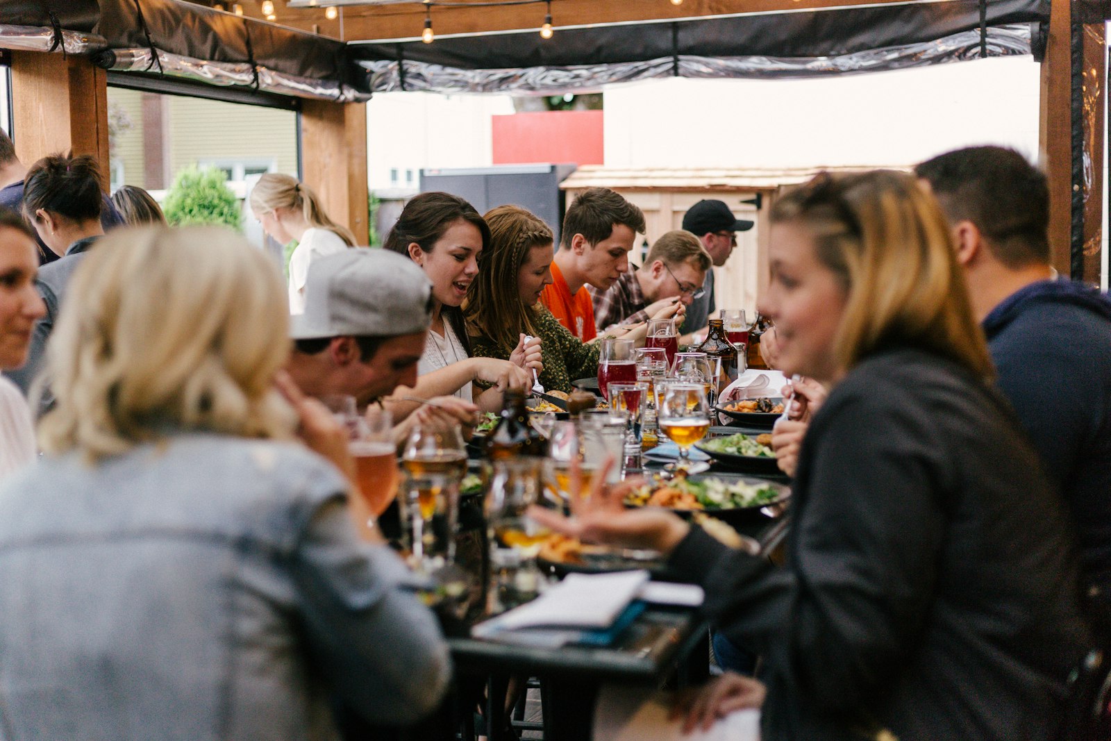 A group of people sharing a meal and conversation around a long table, representing the in-person relationships behind lasting partnerships