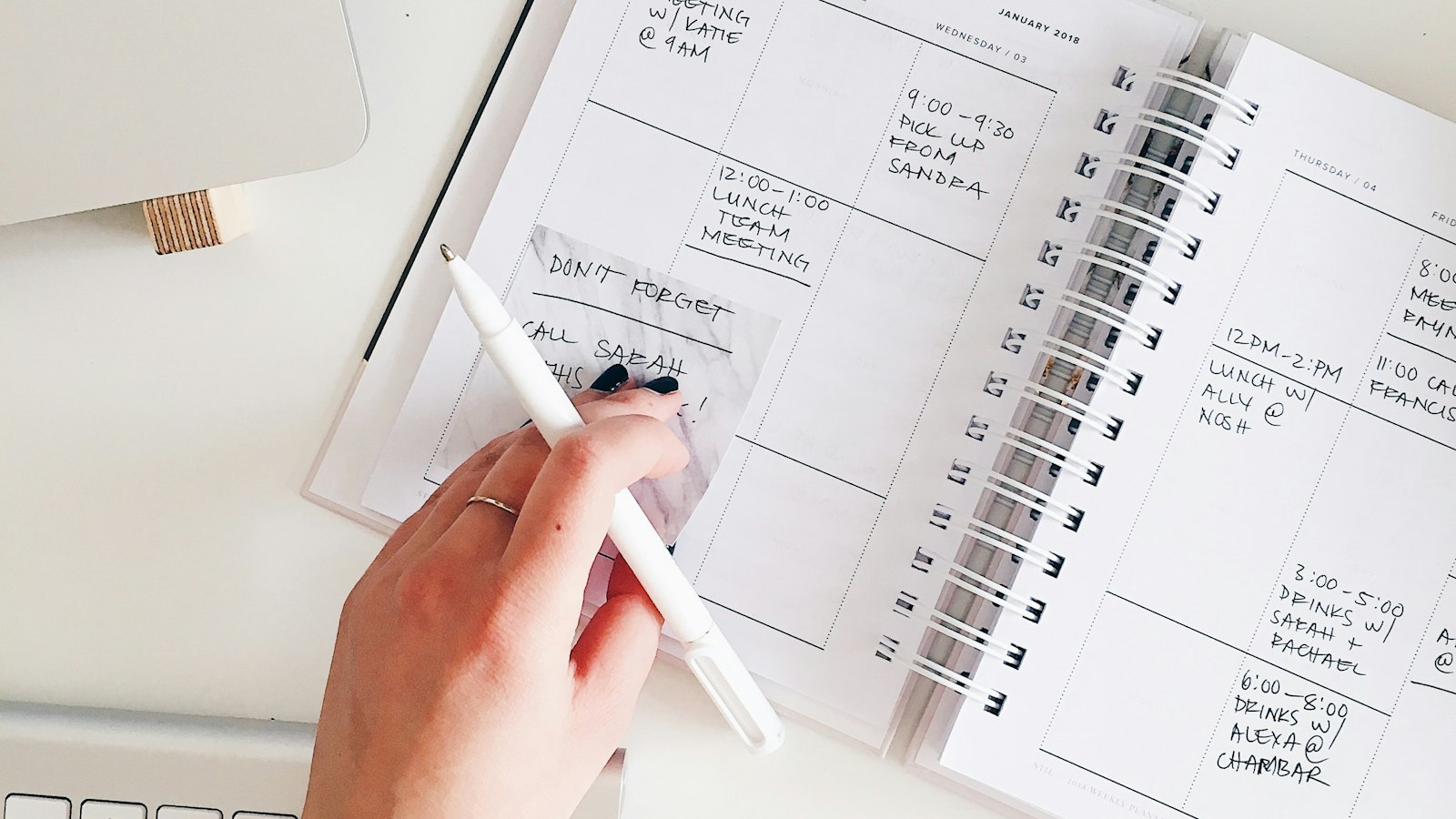 A person holding a notepad and pen over a desk, representing planning which AI workflow to improve first