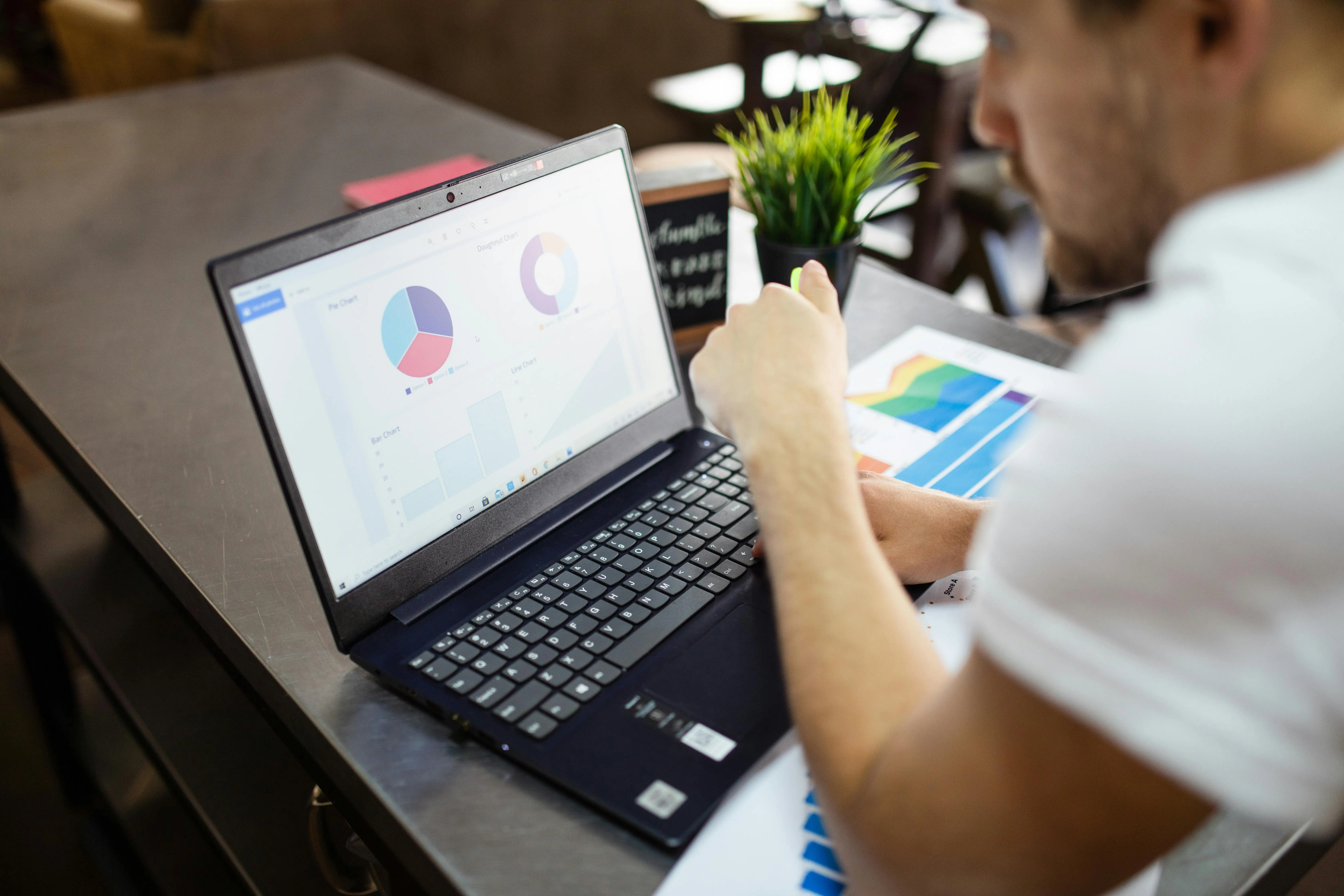 An entrepreneur reviews business performance data on a laptop dashboard — the kind of real-time visibility that reporting systems make possible