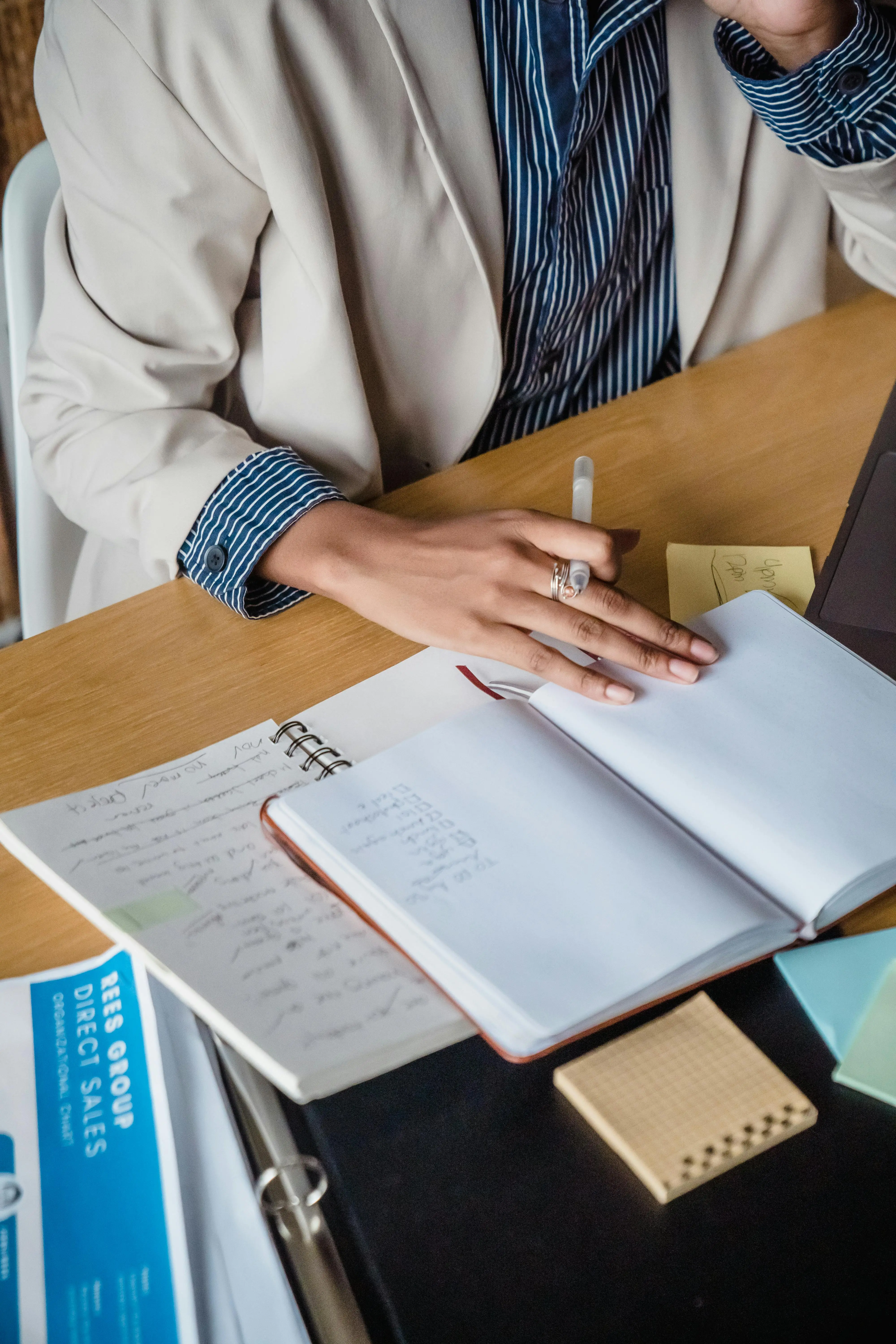 A business professional writing notes during a lead follow-up strategy session, representing the challenge of manual pipeline management for coaches and consultants