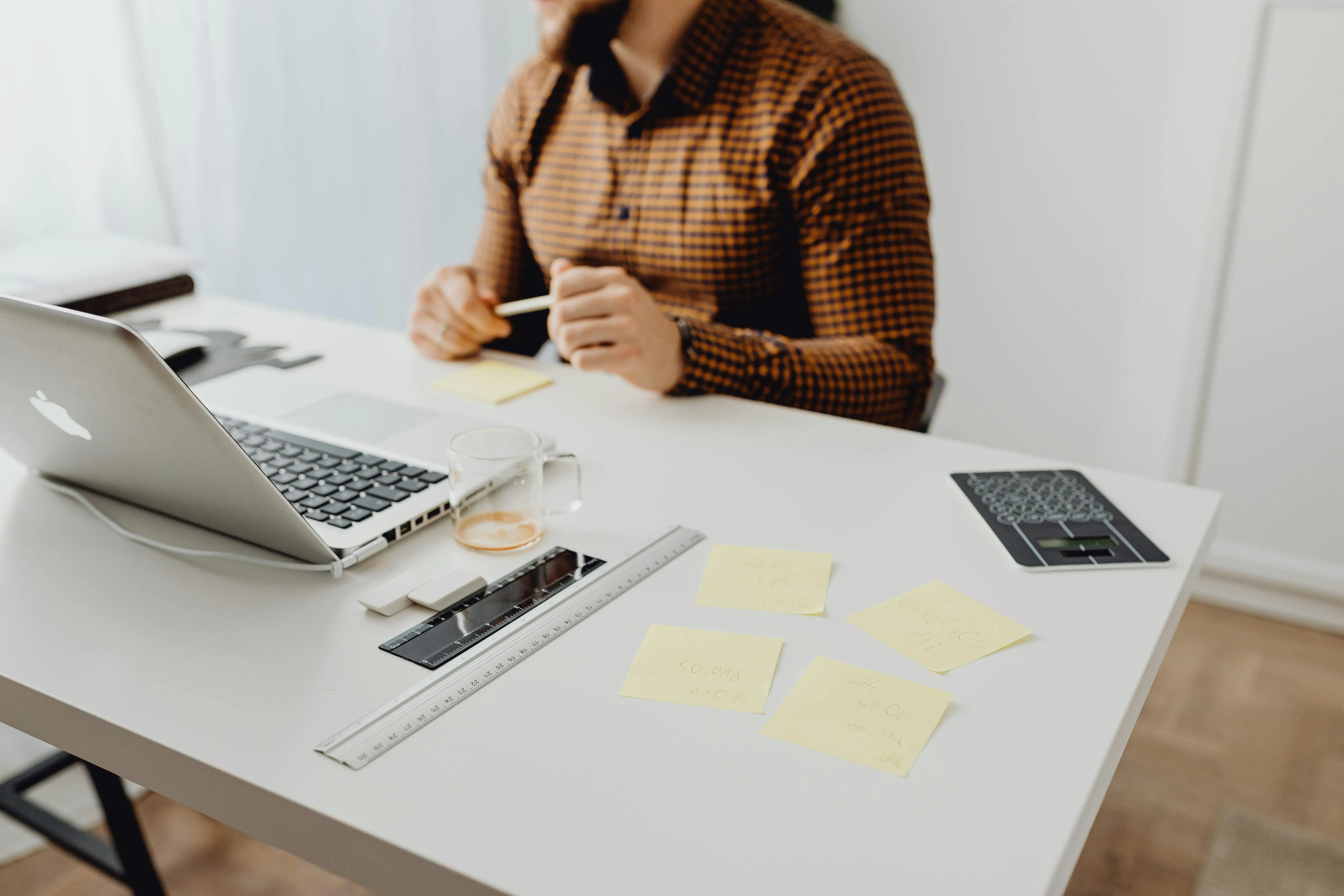 An entrepreneur seated alone at a desk surrounded by planning materials, representing a founder carrying the full operational weight of a growing business