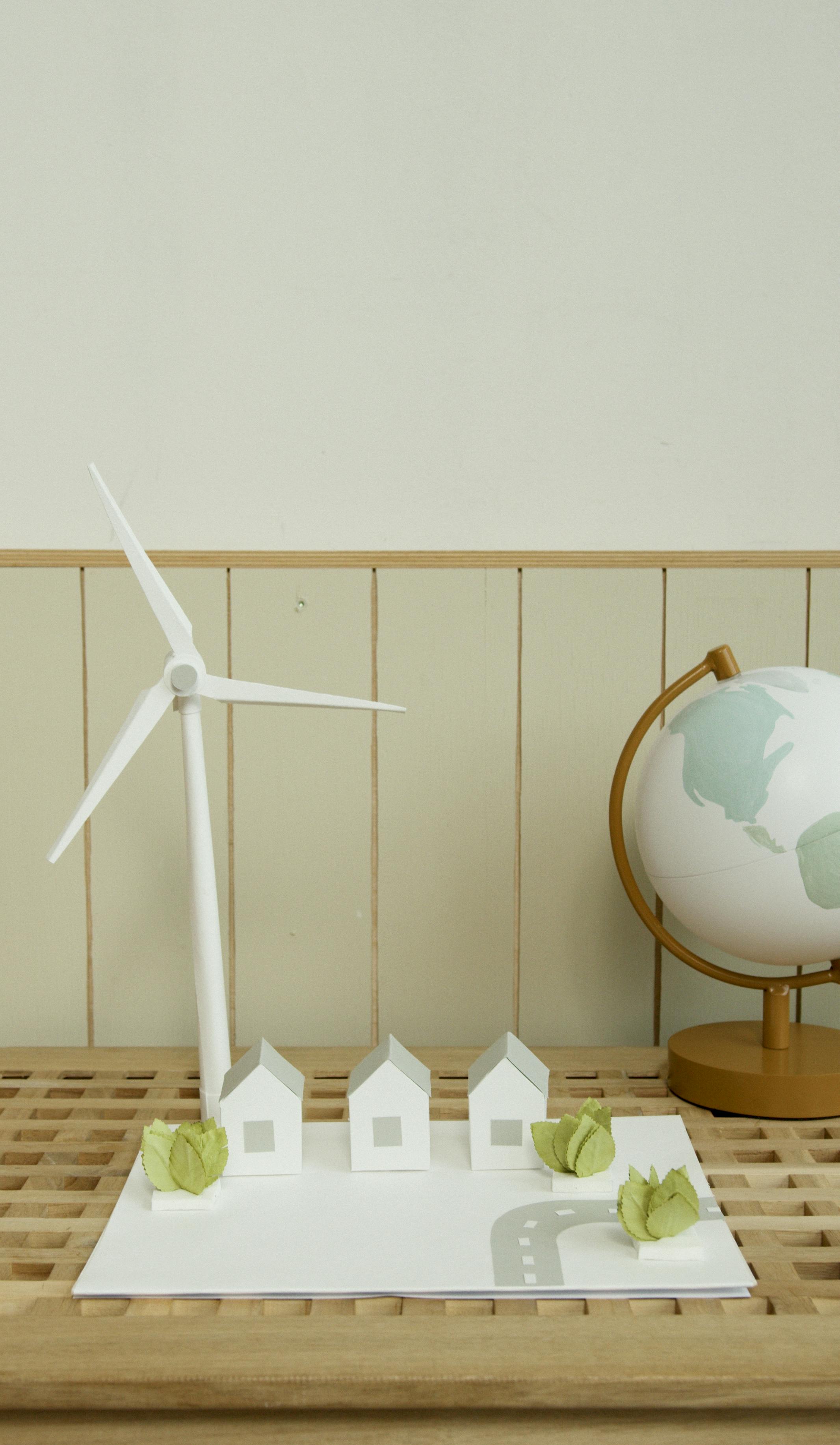 Small white and red house model resting on a wooden table — a classic representation of residential real estate investment and property ownership planning
