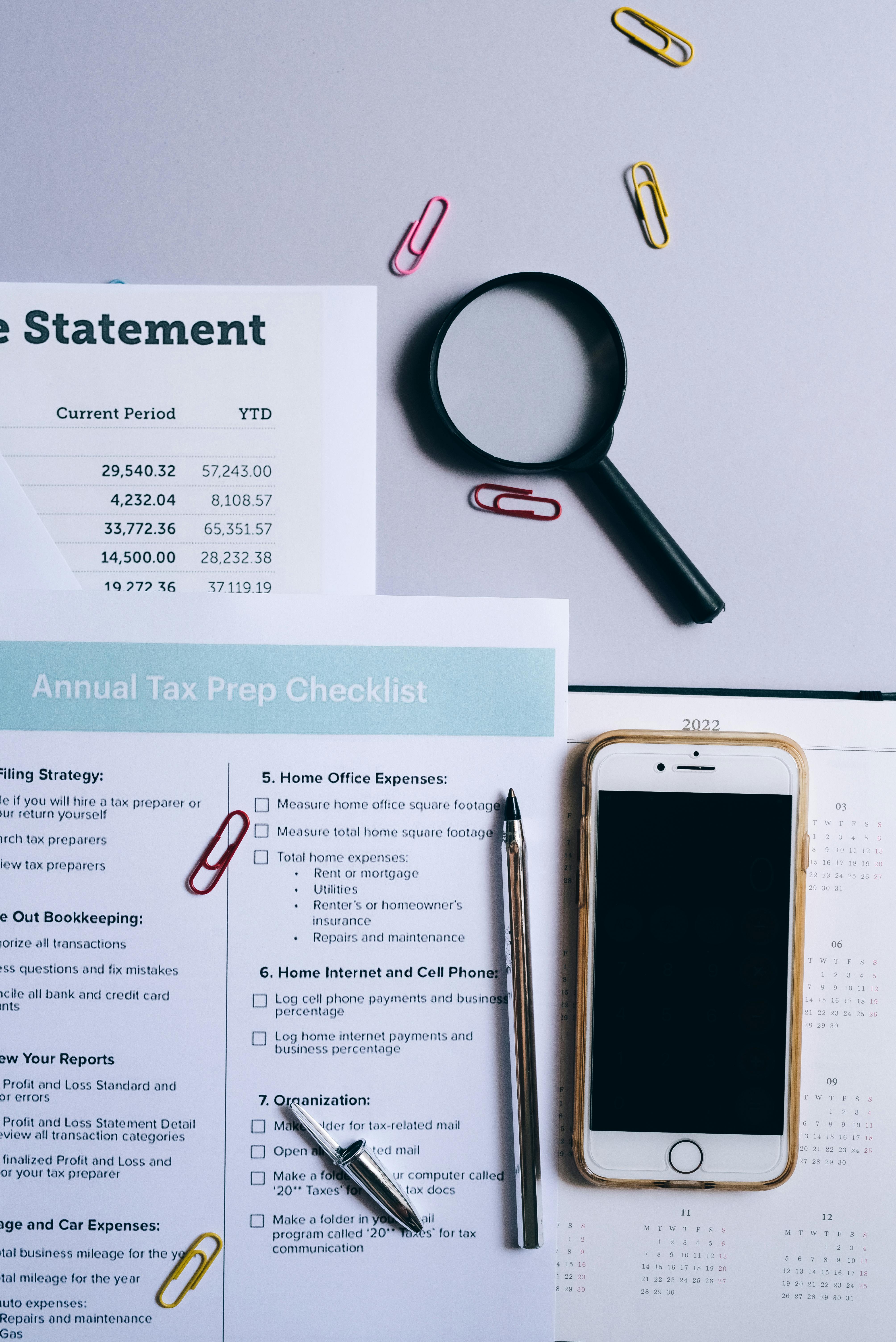 A professional reviewing a structured checklist on a tablet beside an open laptop, representing a systematic AI workflow audit and business process review