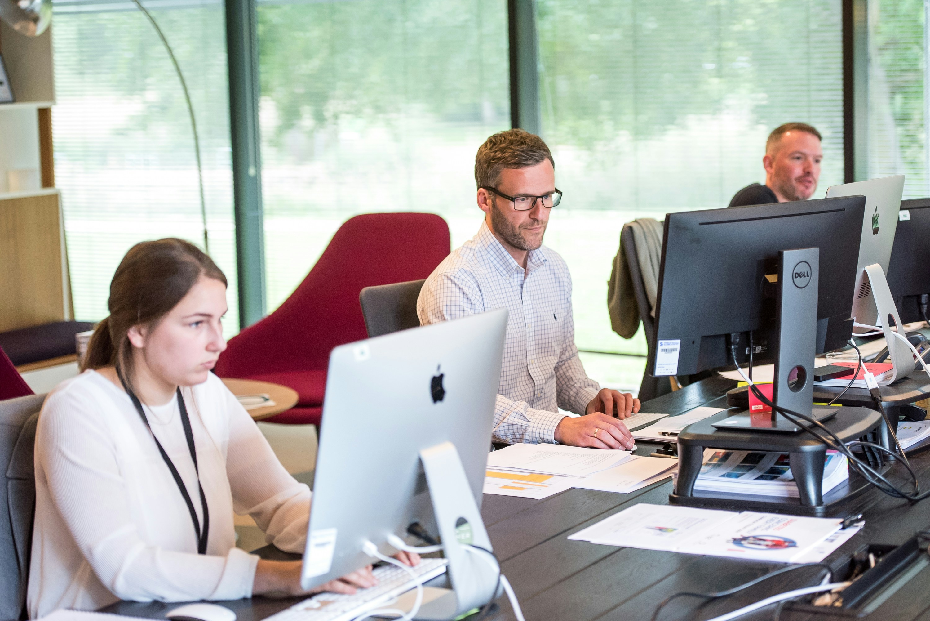 A business team reviews client health scores on a shared screen, using an AI-powered CRM dashboard to identify at-risk accounts before they churn