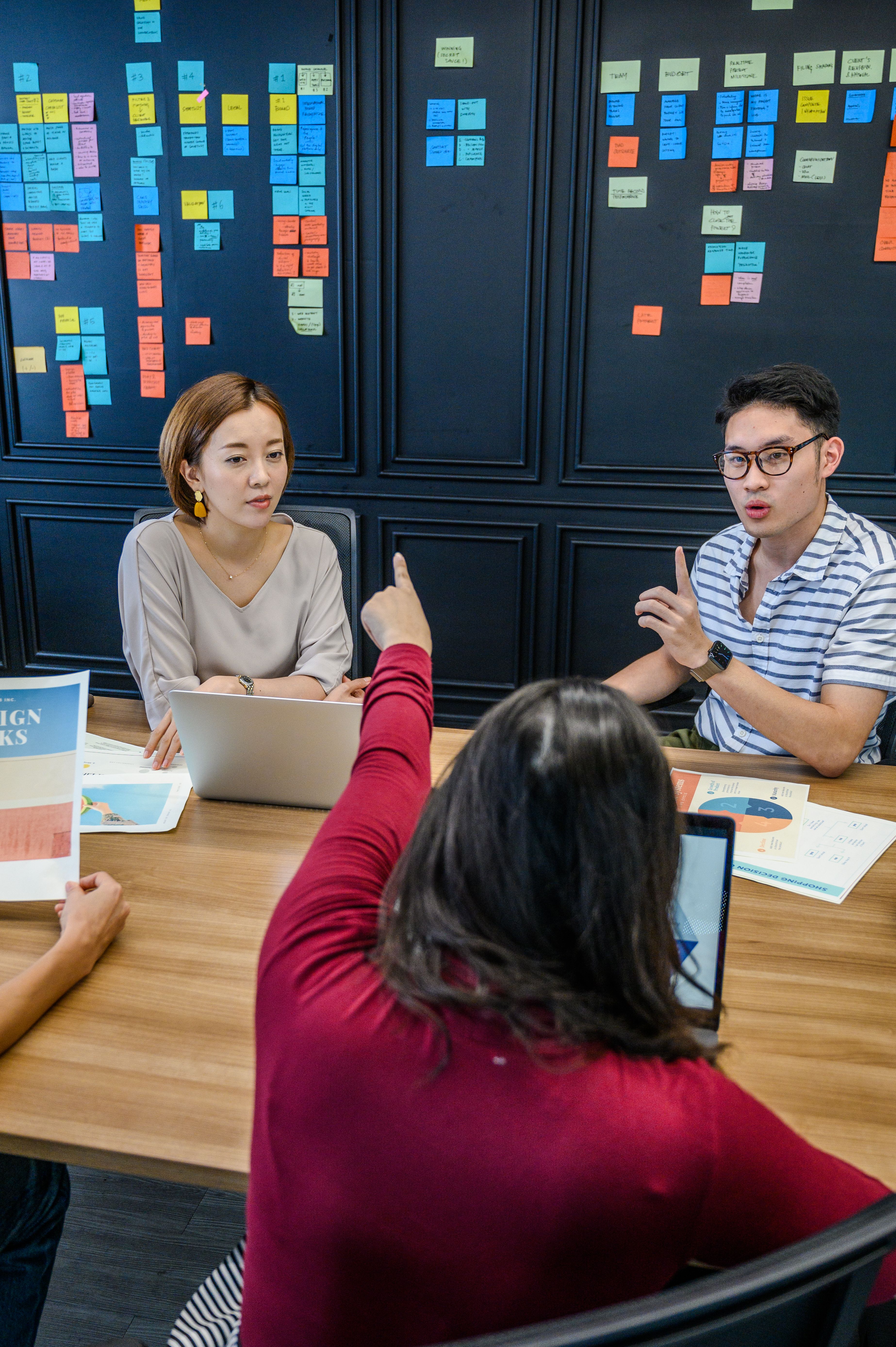 A business team reviews a whiteboard showing a multi-step automated workflow, distinguishing between a simple chatbot response path and a full agentic AI decision sequence