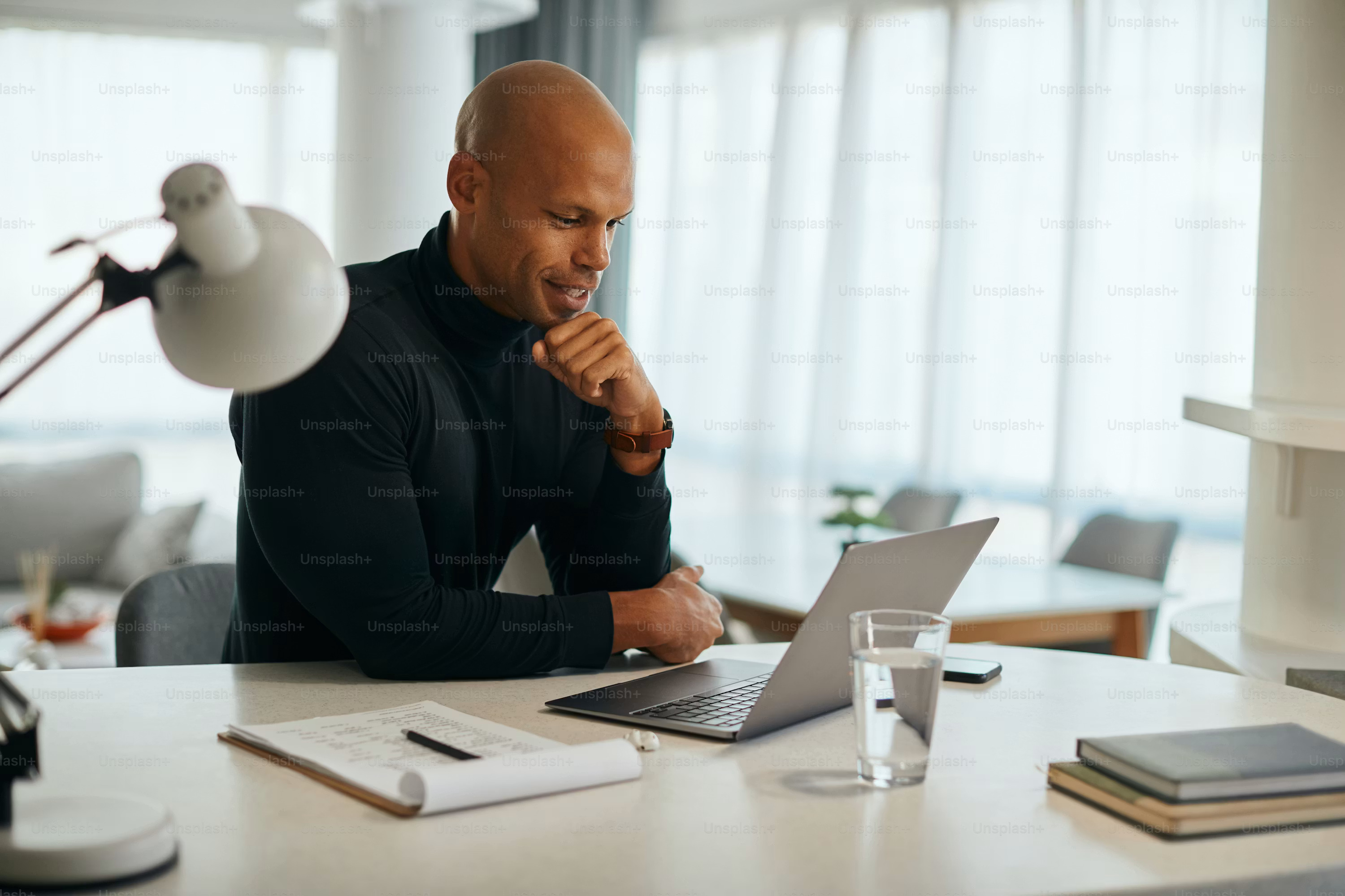 A small business owner works confidently on a laptop at a home office desk, representing the clarity AI cash flow forecasting brings once it's in place