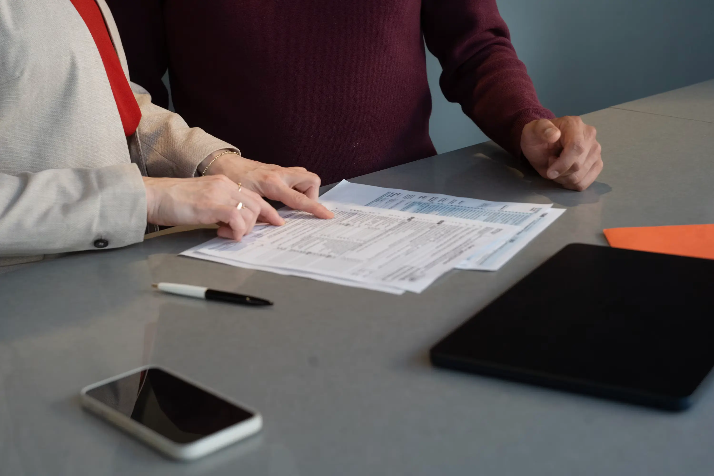 Two colleagues review paperwork together at a table, representing the exception-based human review that AI document processing routes to a person only when something looks unusual