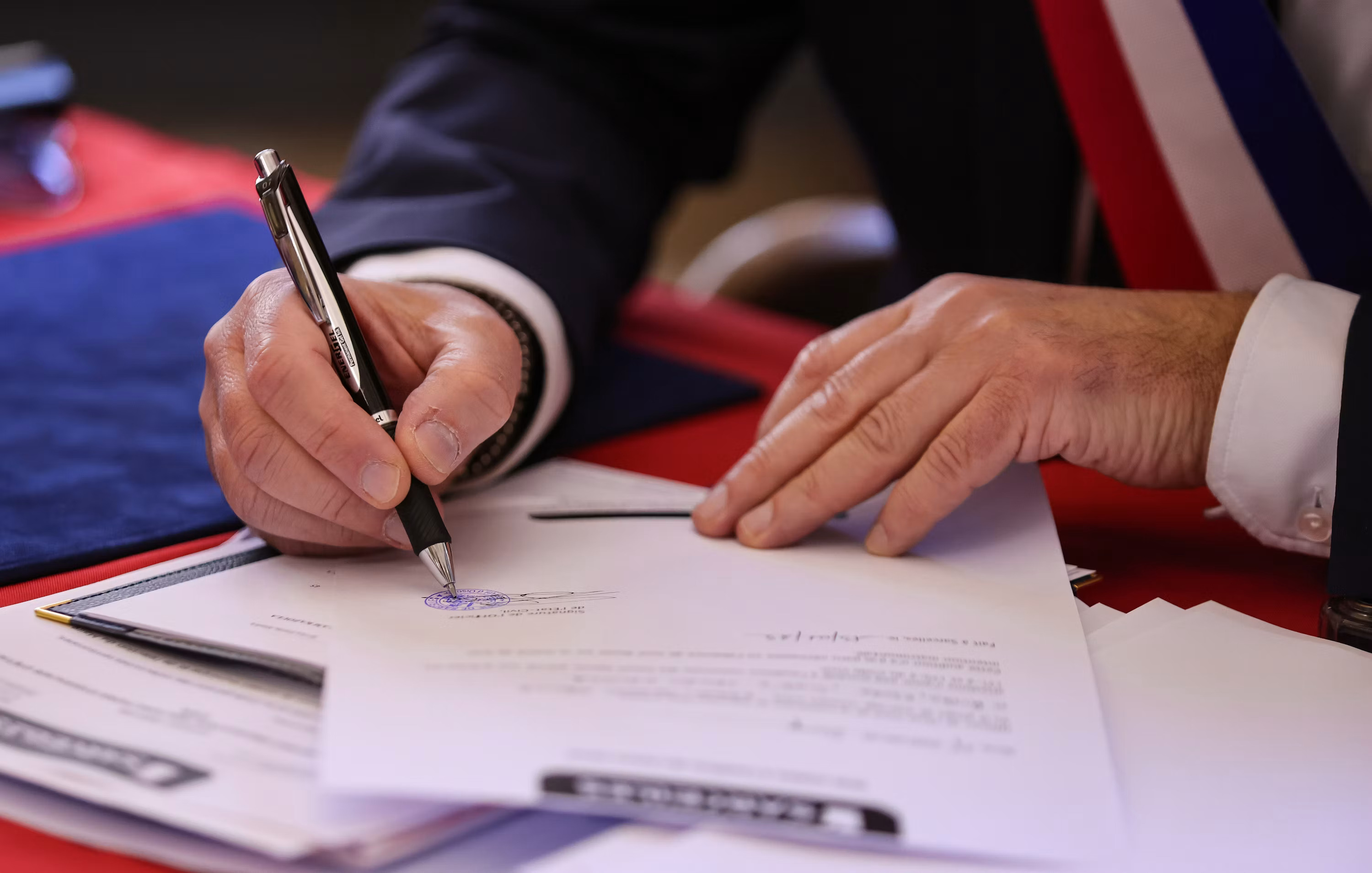 A person signs a document with a pen, representing the moment a business commits to an AI vendor contract before fully vetting it