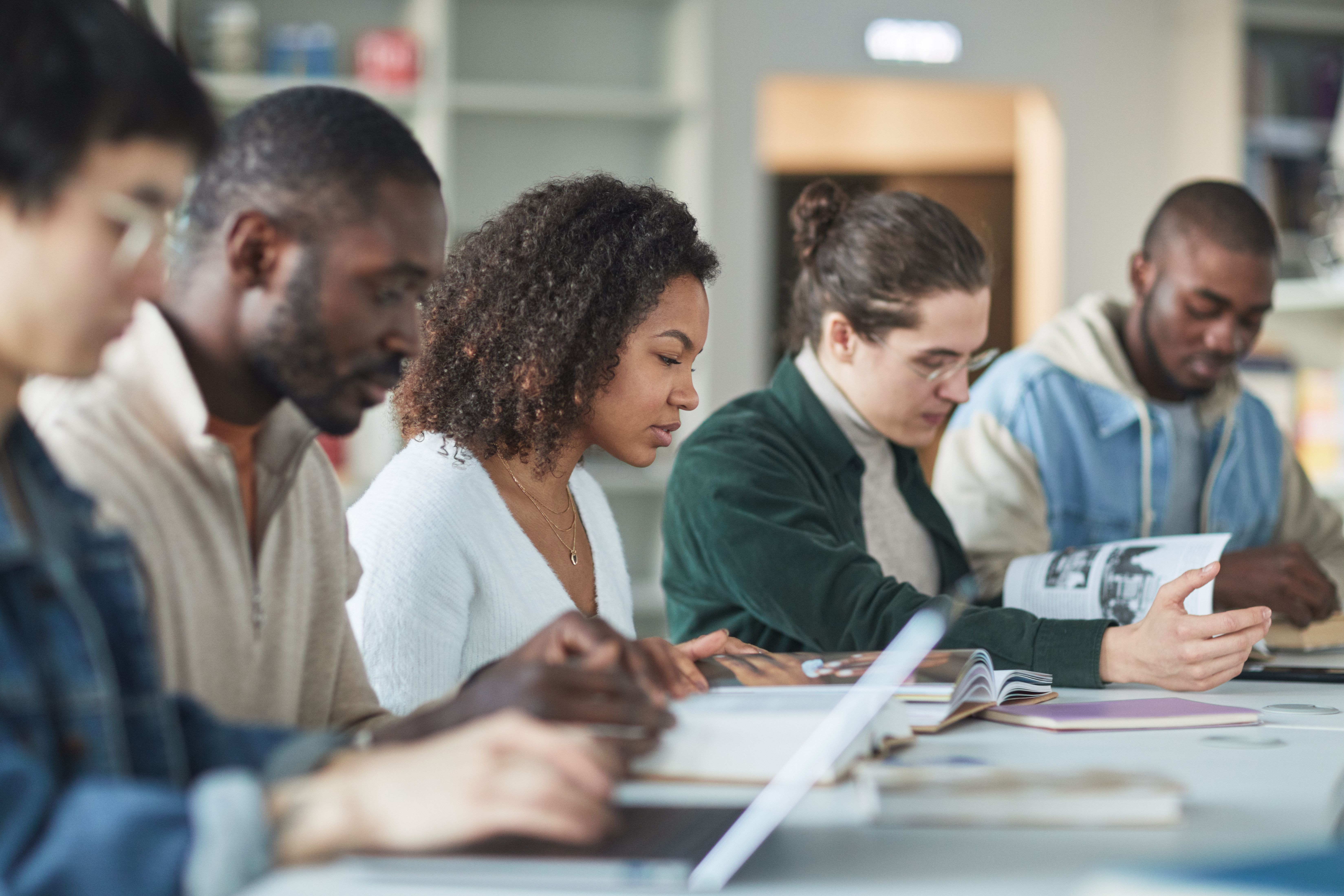 Diverse group of international students studying together in a college library