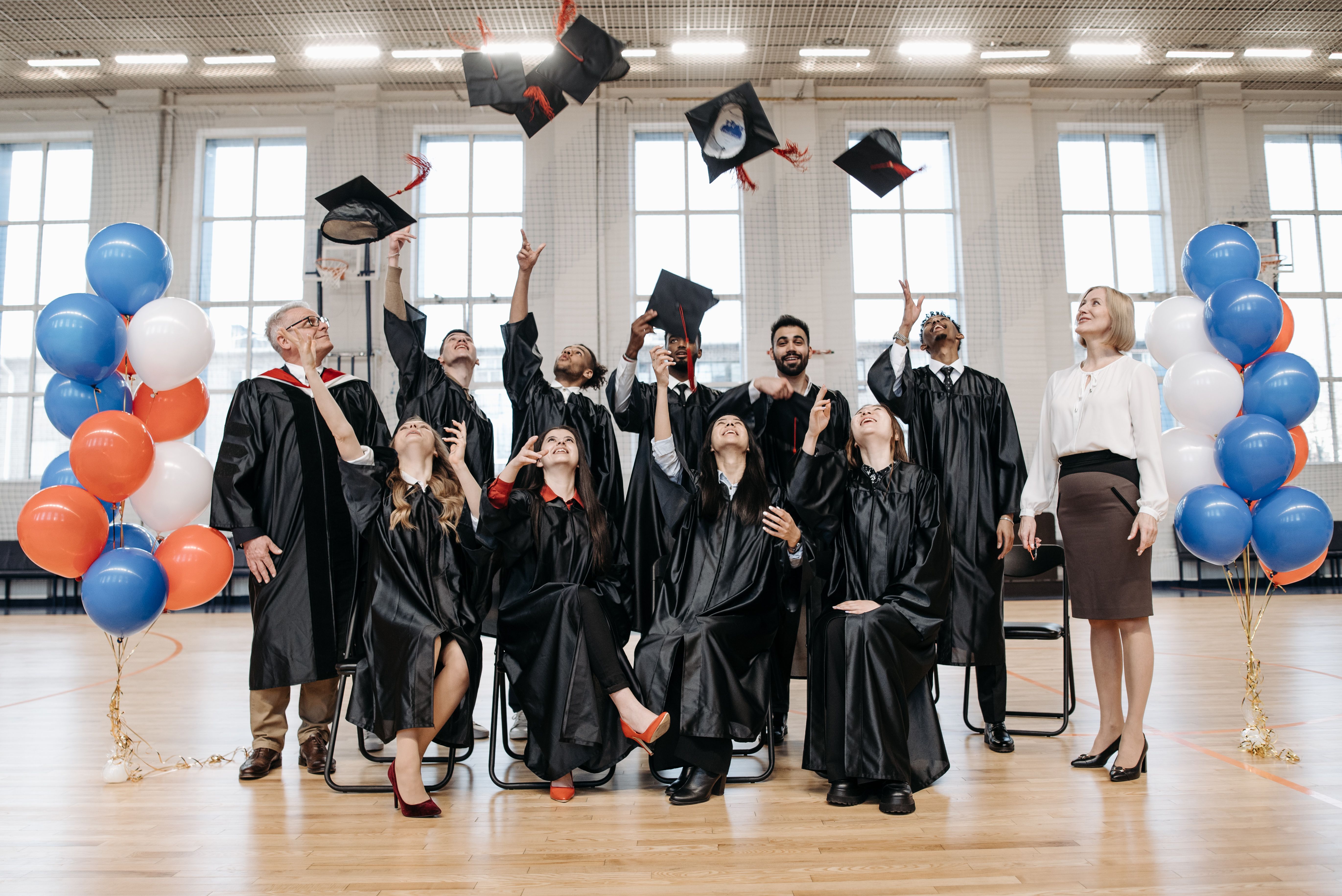 Graduates in caps and gowns celebrating together after completing their Ontario college program