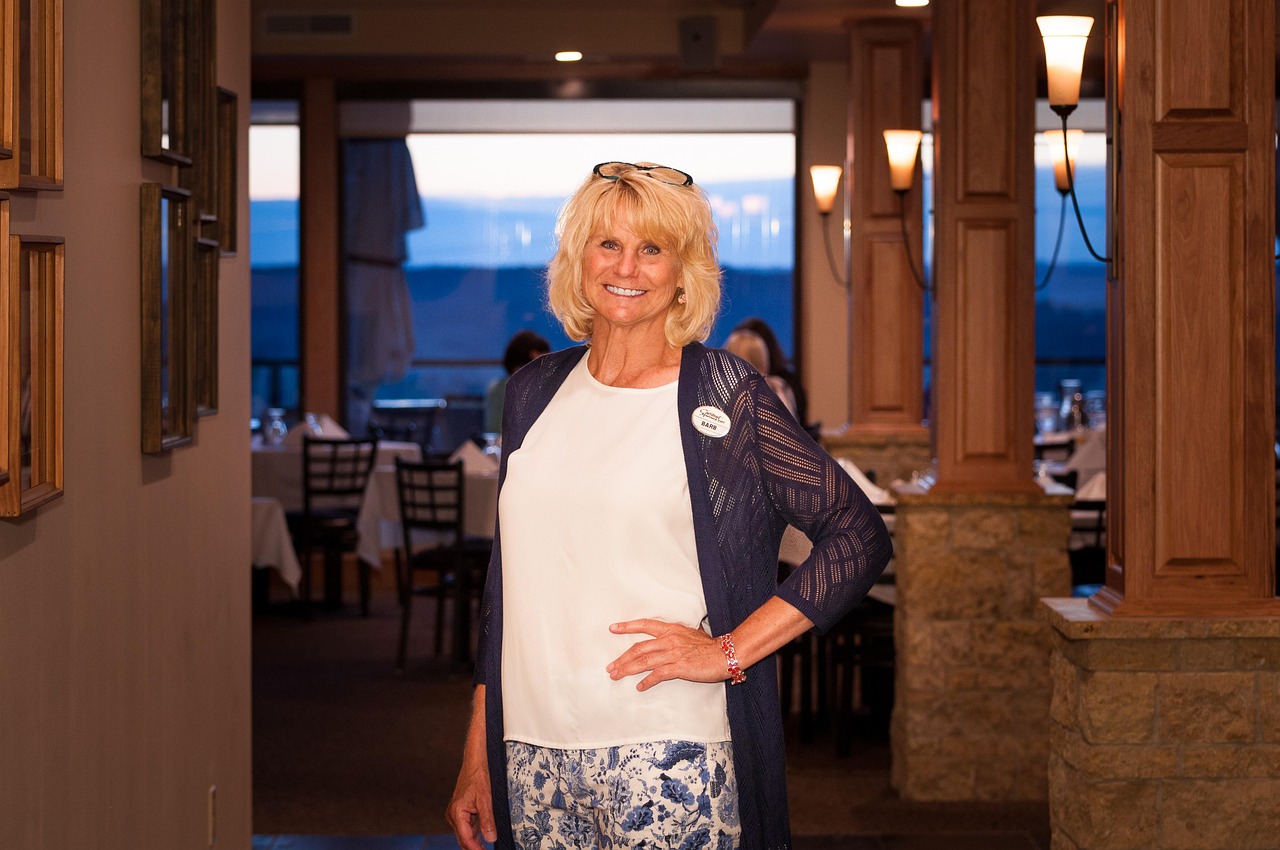 Restaurant hostess greeting guests at the host stand during a busy dinner service