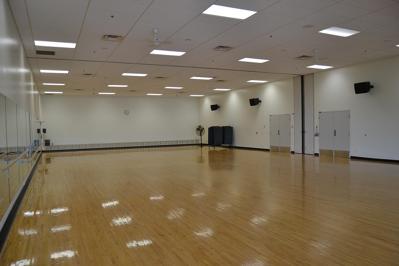 An empty boutique gym studio floor with mirrored walls, ready for the next fitness class, representing the retention and churn challenge fitness studios face in 2026