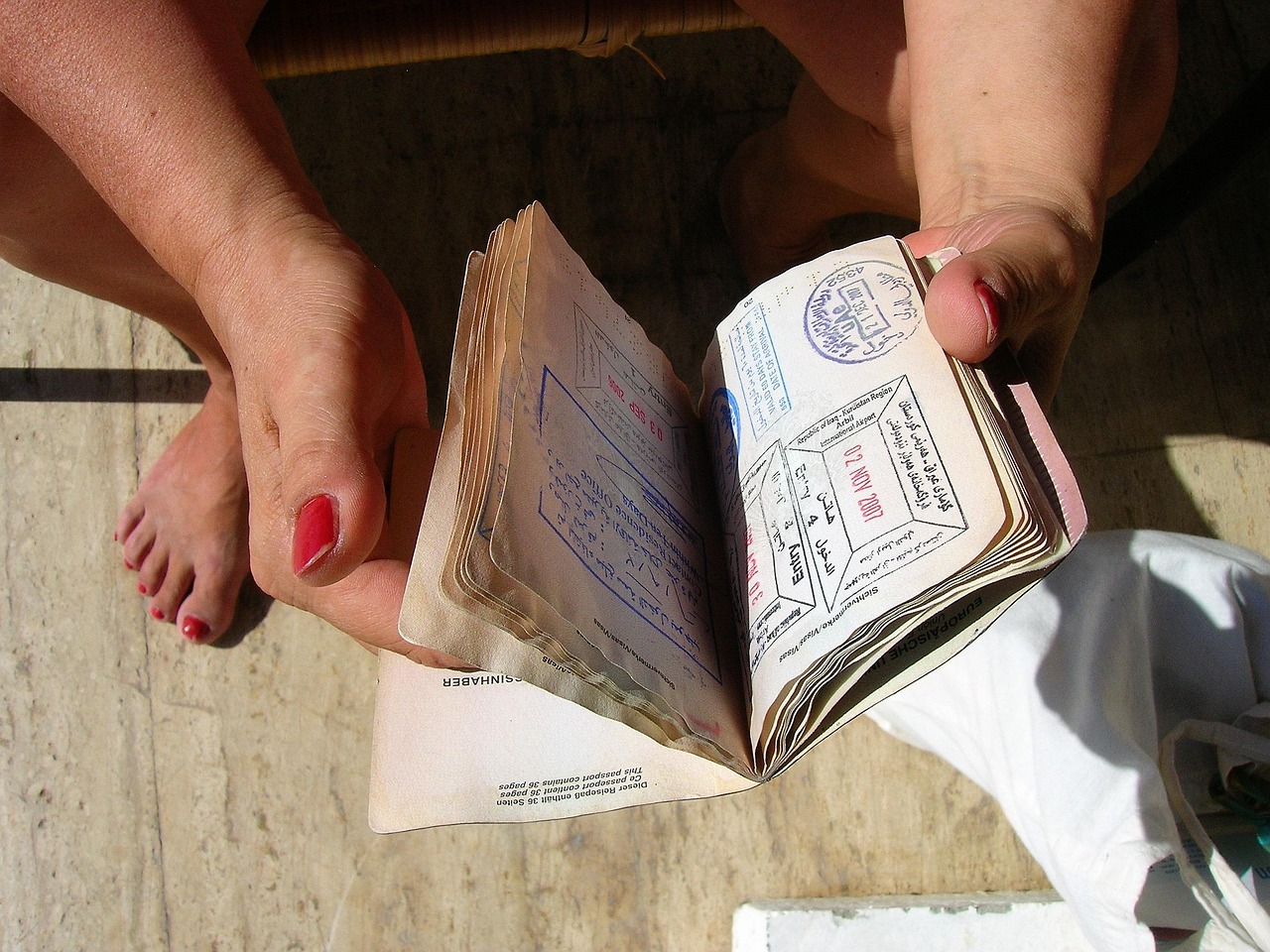 Passport and visa documents being stamped, representing IRCC's compliance investigations into former Student Direct Stream permit holders in 2026
