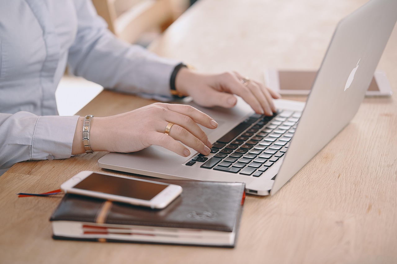 Businesswoman working at a laptop in a modern office, responding to customer messages