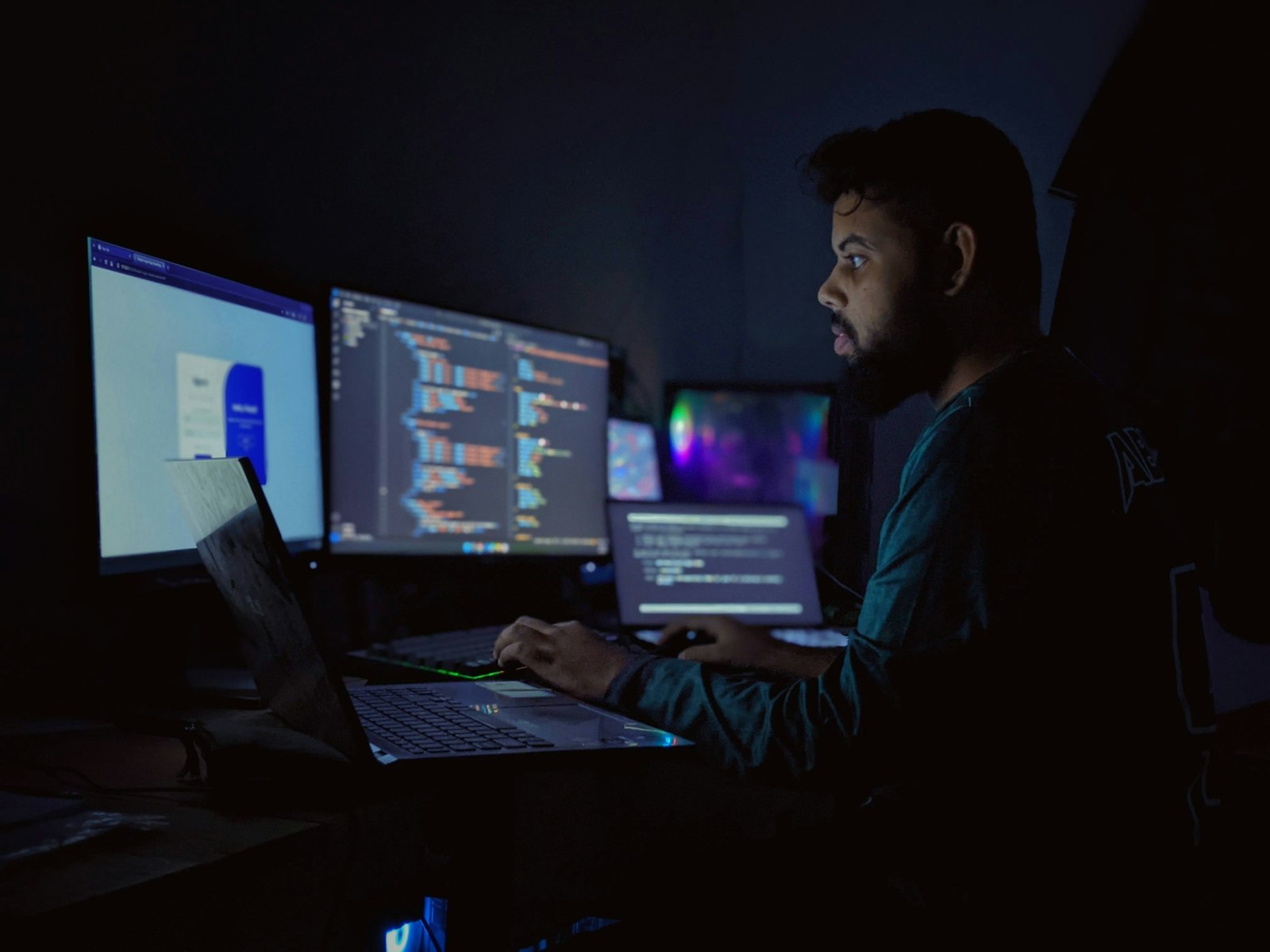 Professional working late surrounded by multiple computer monitors and open dashboards, illustrating AI tool sprawl