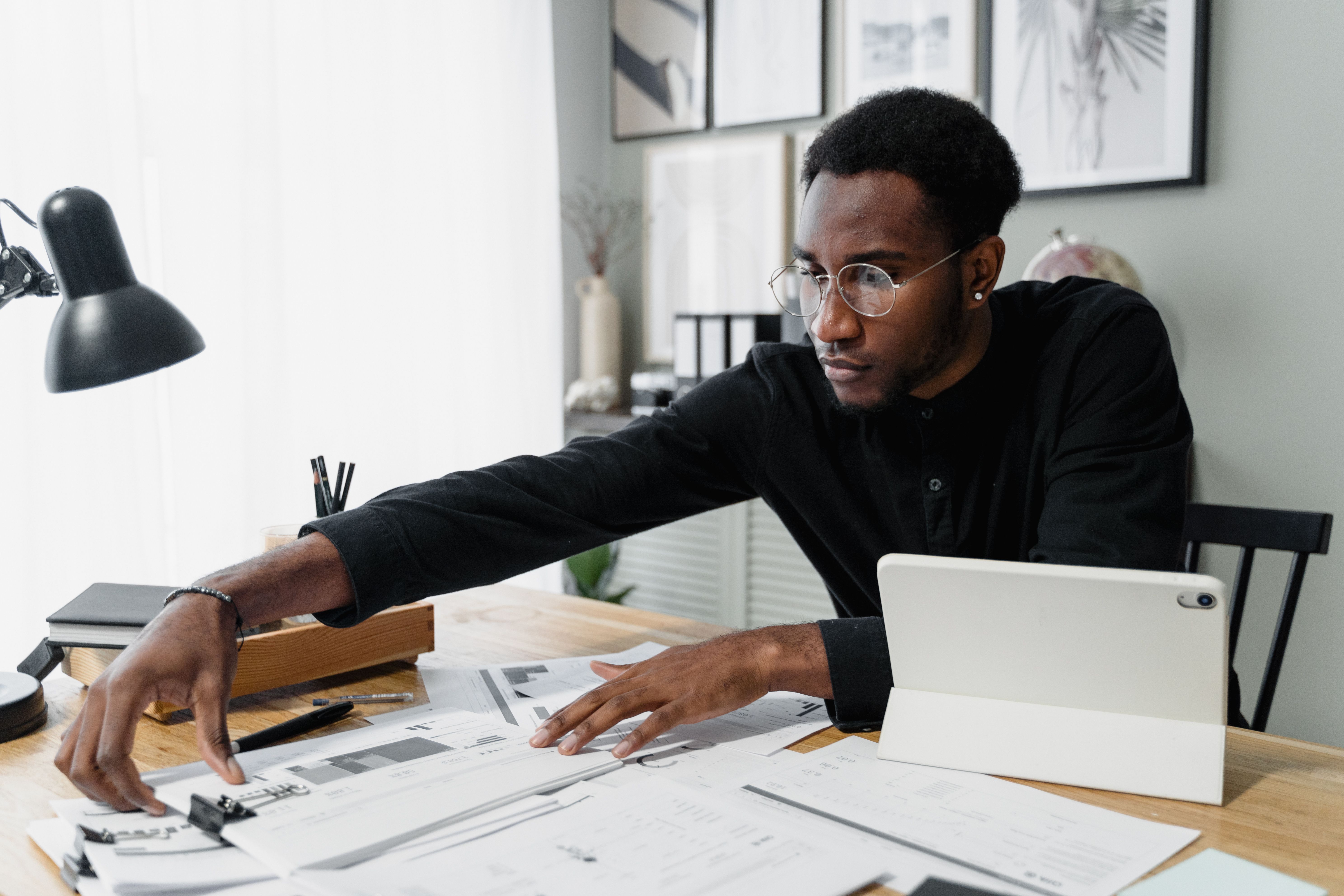 A small business owner reviews financial paperwork at a desk with a concerned expression, reflecting the cost pressures behind Canada's 2026 small business confidence data