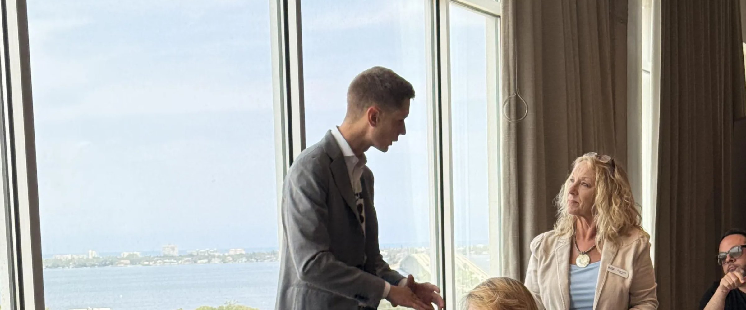 Cameron Smith talking with two agents at an event