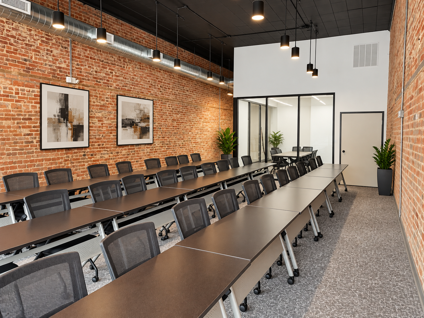 Finished commercial meeting space with brick walls, glass partitions and modern furnishings