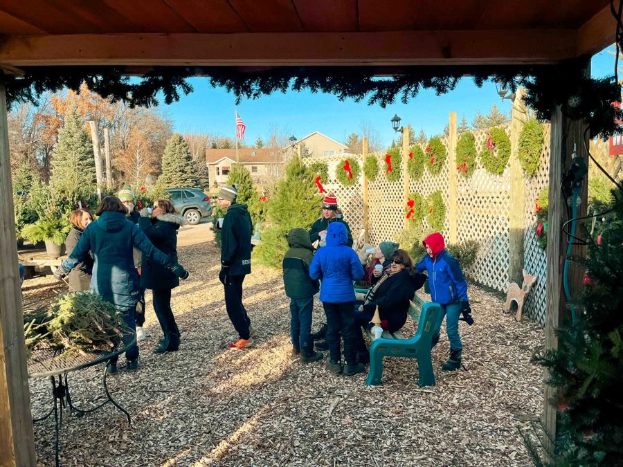 Families gather at the farm stand under garland and wreaths