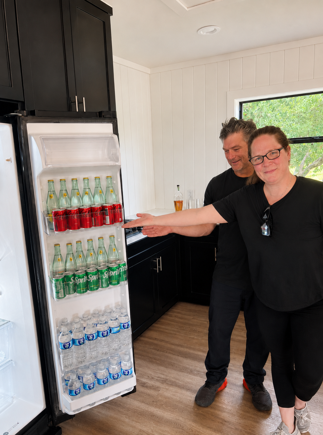 Amy from Behind the Scenes Concierge stocking a vacation rental refrigerator with drinks and groceries for guests