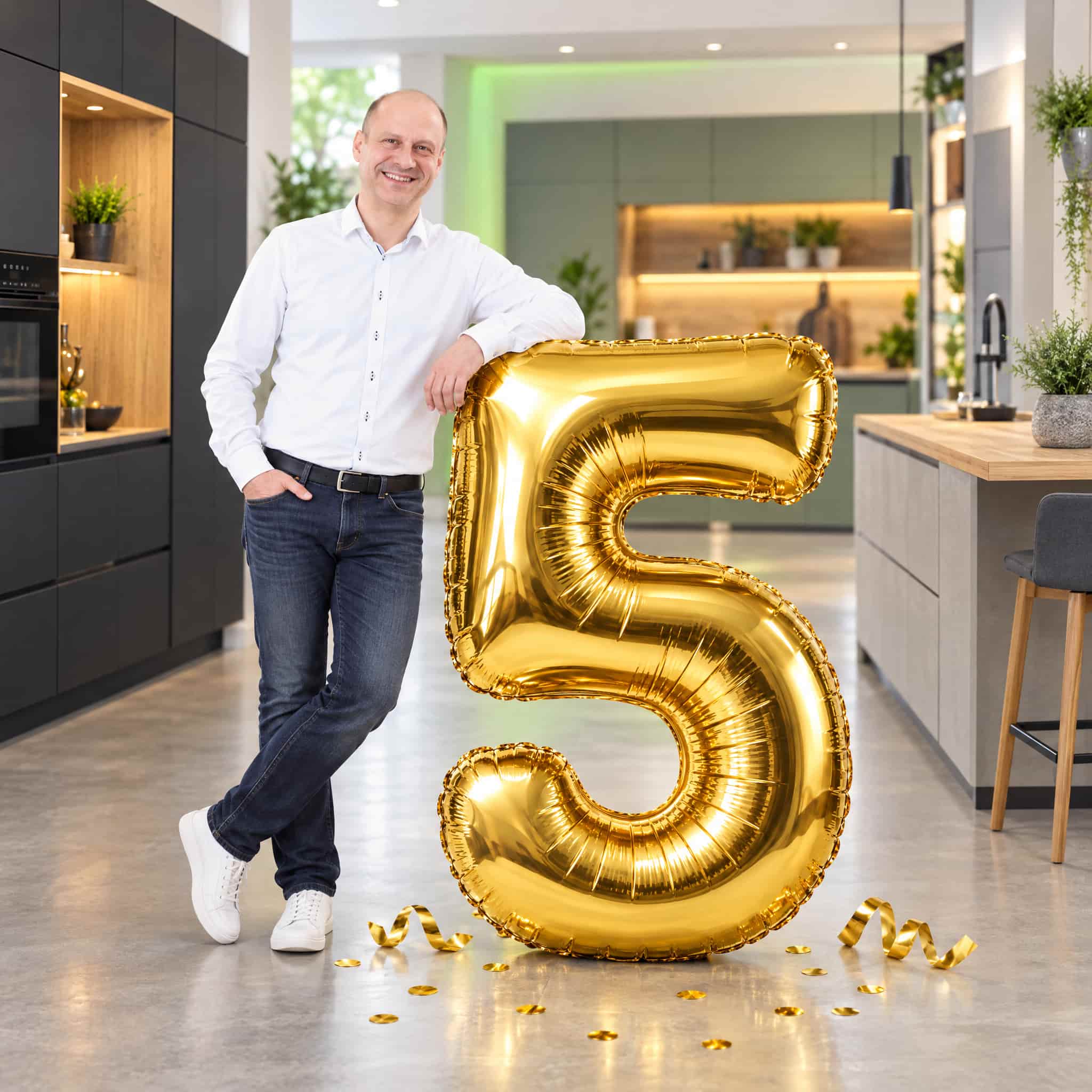 Bartholomäus Orlowitz mit goldener 5 im Showroom von Clever Küchen