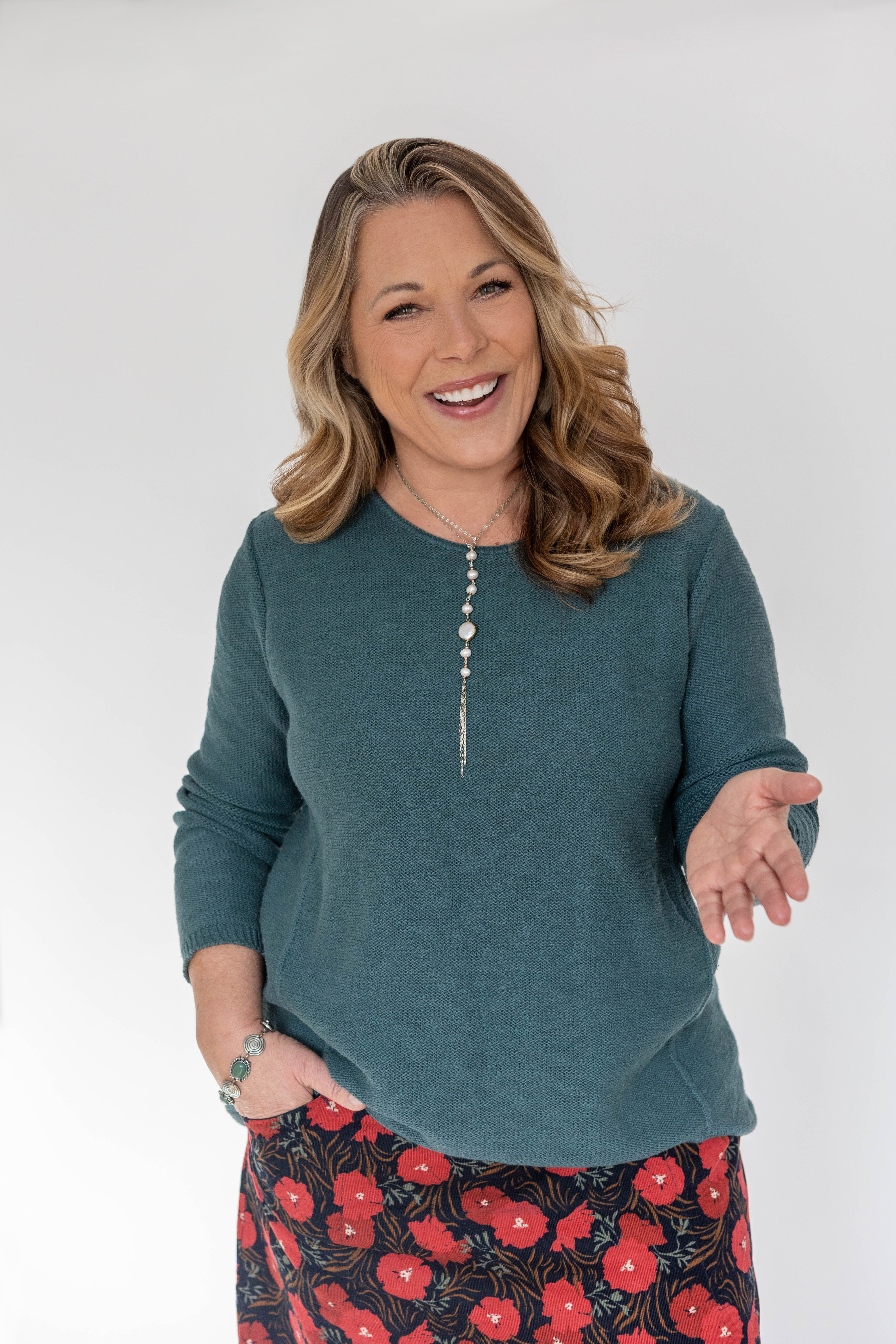 Pasha speaking on stage smiling, with hands clasped together at a Community event.