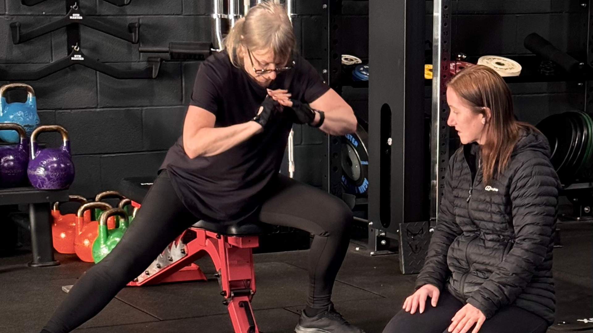 Infinity coach guiding a member through a movement