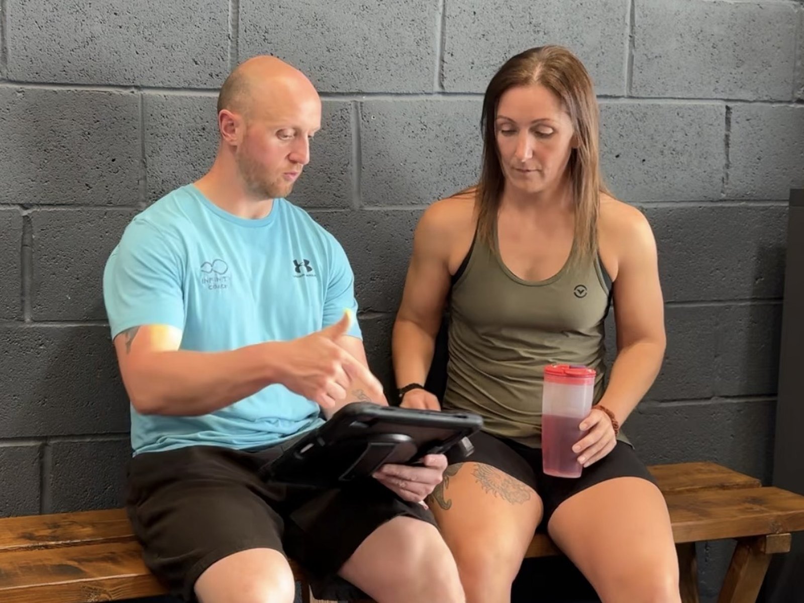 Infinity coach going through details with a member on an iPad