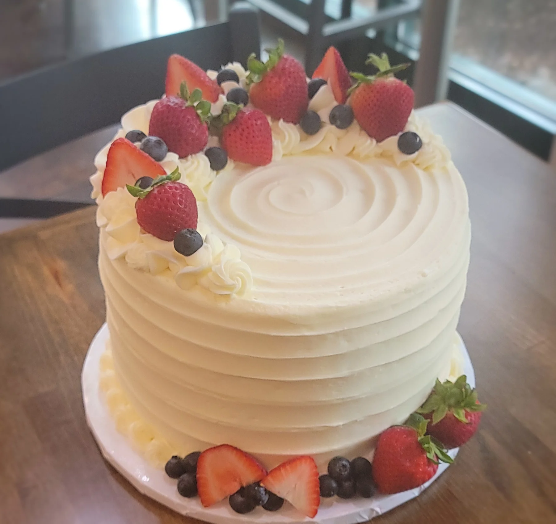 Vanilla cake topped with fresh strawberries and blueberries