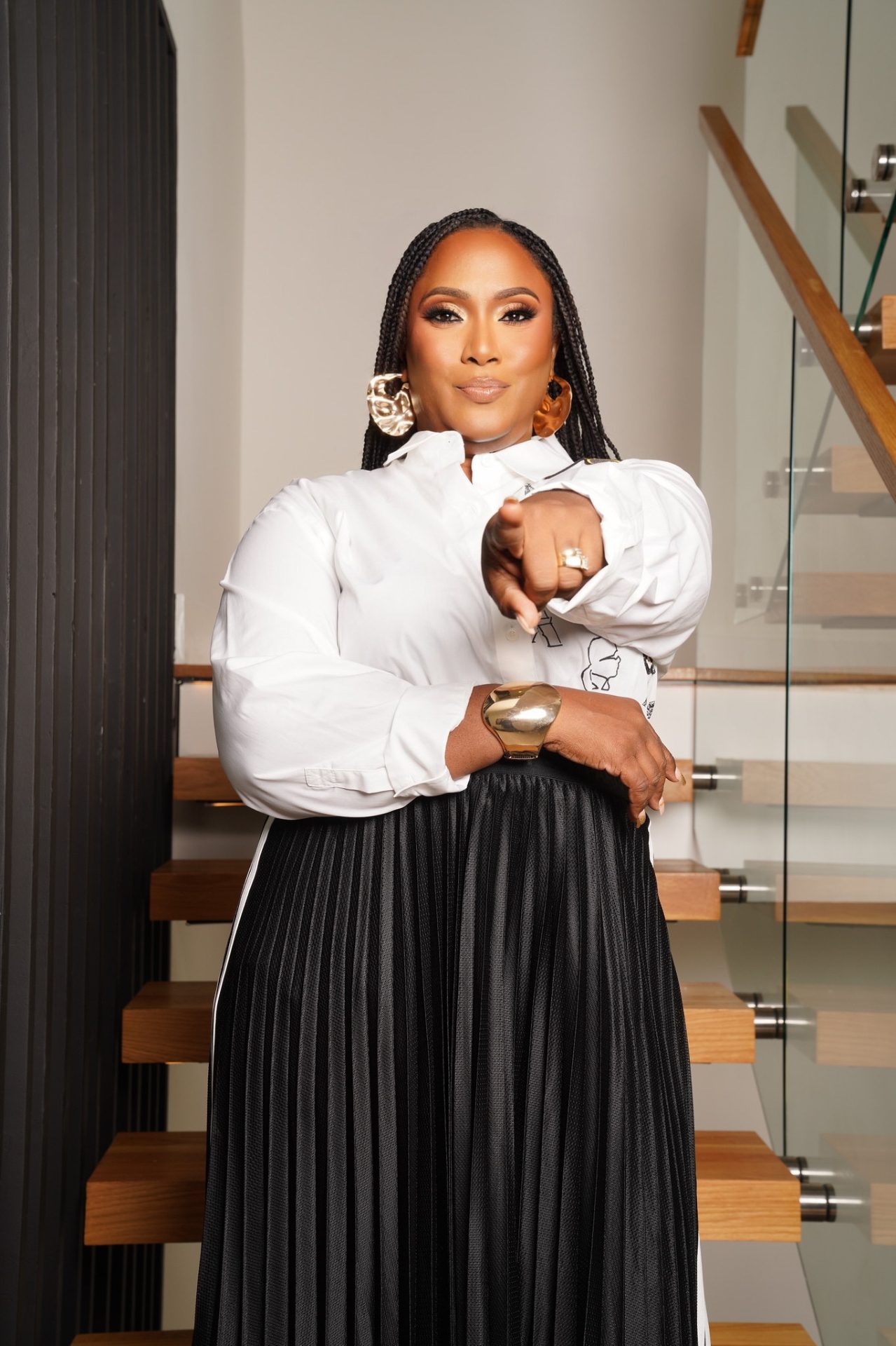 Dr. Lynda A. Barnes on a staircase pointing toward the camera