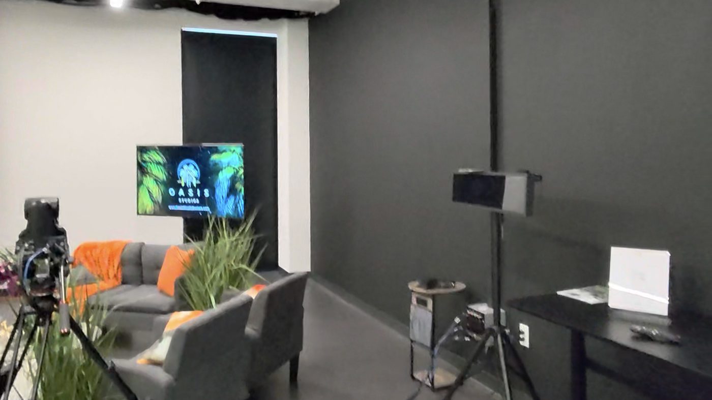 Studio interview set with sofas and a wall-mounted display screen
