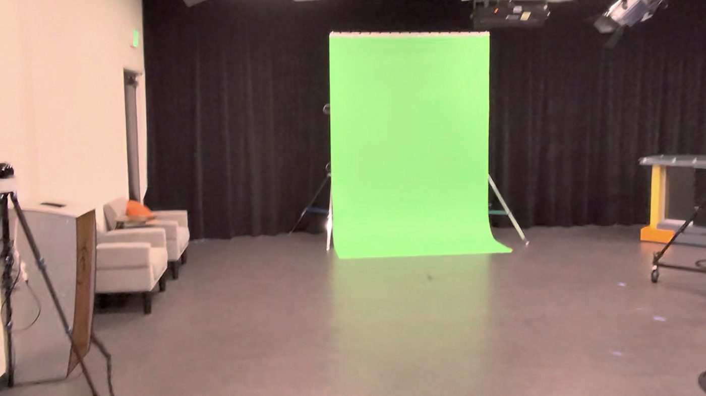 Full green screen under a studio lighting grid